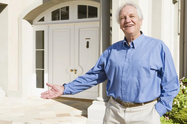 Senior man standing outside house — Stock Photo, Image