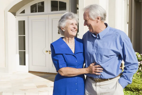 Senior couple standing outside house — Stock Photo, Image