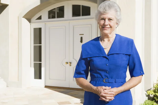 退休的女人站在房子前面 — 图库照片