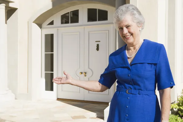 Senior Woman Welcoming Guests Home — Stock Photo, Image
