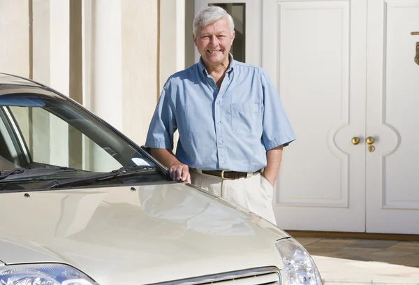 Старший мужчина, стоящий рядом с новой машиной — стоковое фото