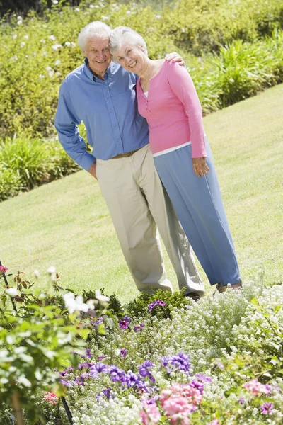 Äldre par stående i trädgården — Stockfoto