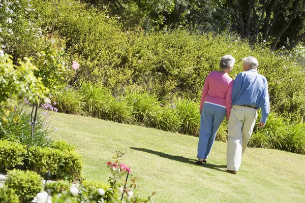 Äldre par promenader i trädgården — Stockfoto