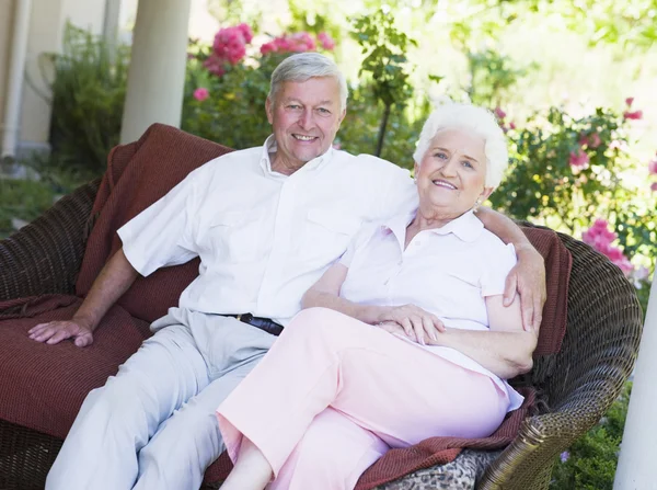 Seniorenpaar entspannt auf Gartensitz — Stockfoto