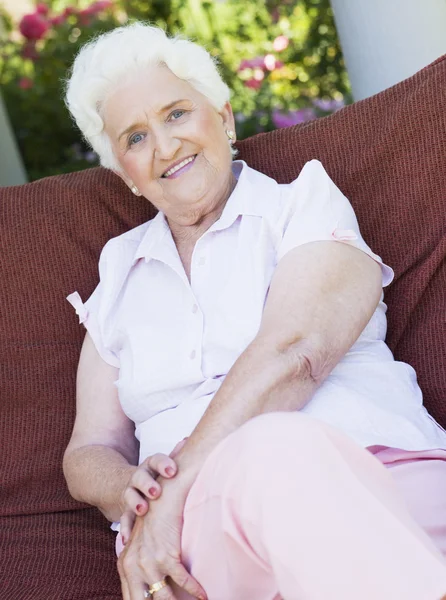 Senior mulher sentada na cadeira de jardim — Fotografia de Stock