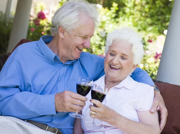 赤ワインのガラスを祝っている年配のカップル — ストック写真