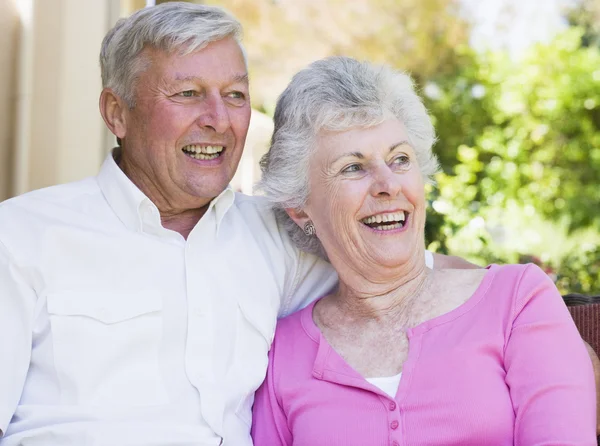 庭座席の上に座って一緒に笑っている年配のカップル — ストック写真