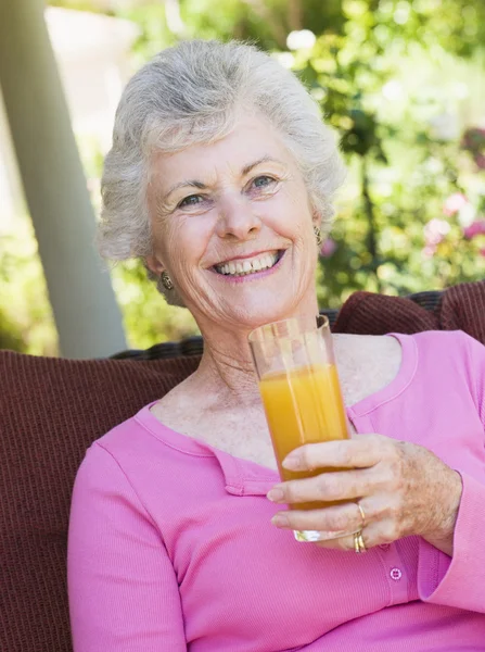 Senior vrouw genieten van glas sap — Stockfoto
