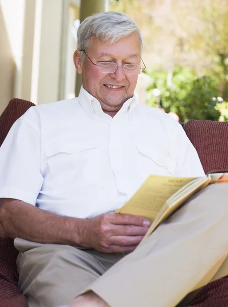 Senior mannen avkopplande med bok — Stockfoto