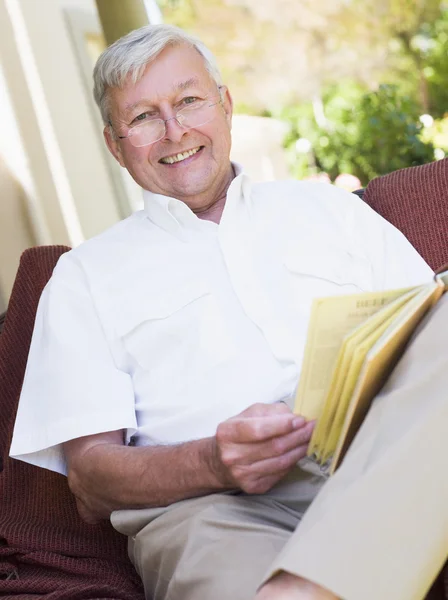 Senior mannen avkopplande med bok — Stockfoto