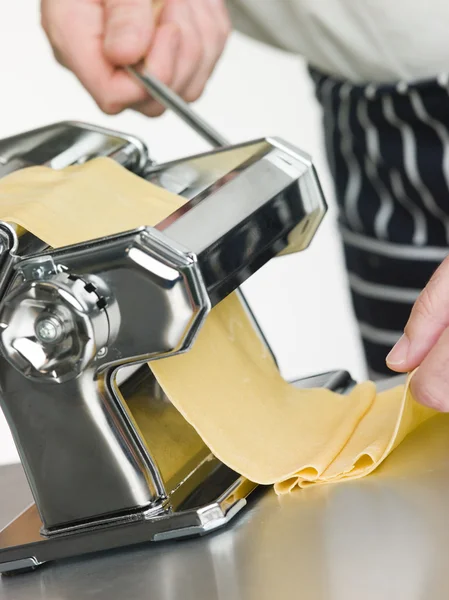 Pâtes aux oeufs fraîches en cours de roulage dans une machine à pâtes — Photo
