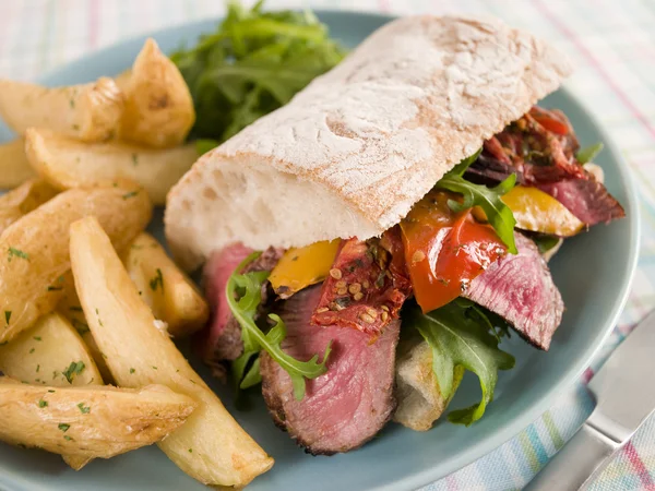 Steak und gebratene Paprika Ciabatta Sandwich mit gewürzten Kartoffeln wir — Stockfoto