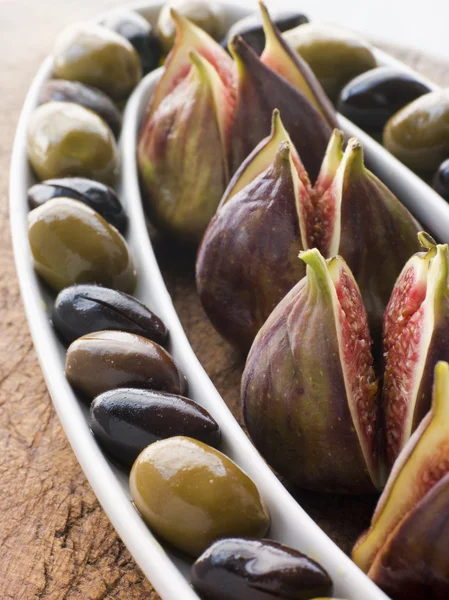 Miska zelených a černých oliv s čerstvé fíky — Stock fotografie