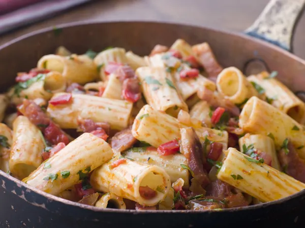 Pan rigatoni pasta med tomatsås och pancetta — Stockfoto