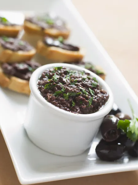 Black Tapenade on Toasts — Stock Photo, Image