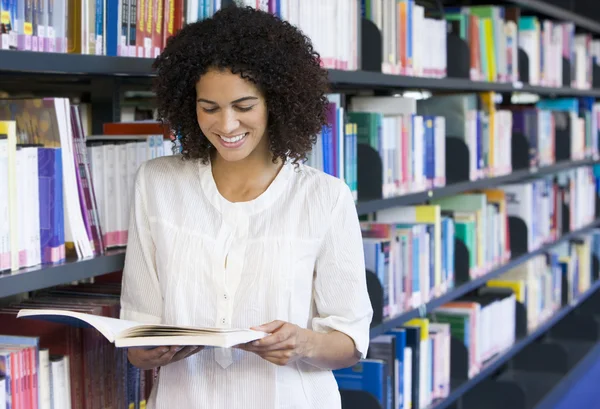 Vrouw leest in een bibliotheek — Stockfoto