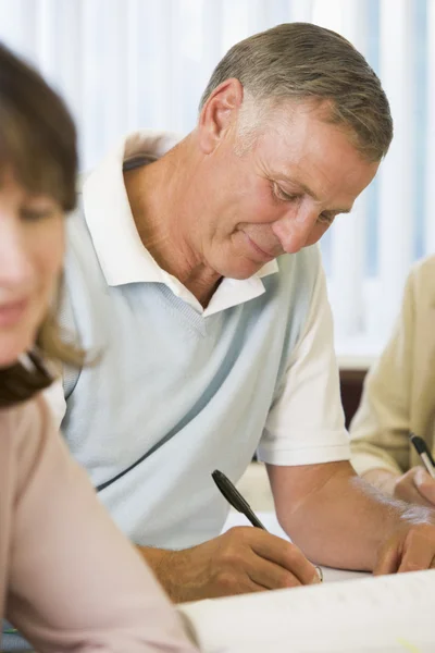 Senior man studying with other adult students — Stock Photo, Image