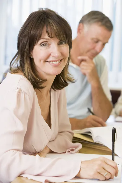 Middle aged woman studying with other adult students — Stock Photo, Image