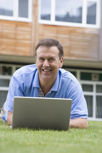 Человек Использующий Ноутбук Лежа Траве Кампусе — стоковое фото