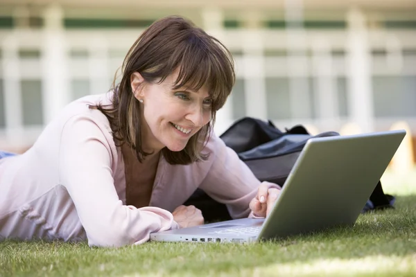 Γυναίκα χρησιμοποιώντας φορητό υπολογιστή στην πανεπιστημιούπολη — Φωτογραφία Αρχείου