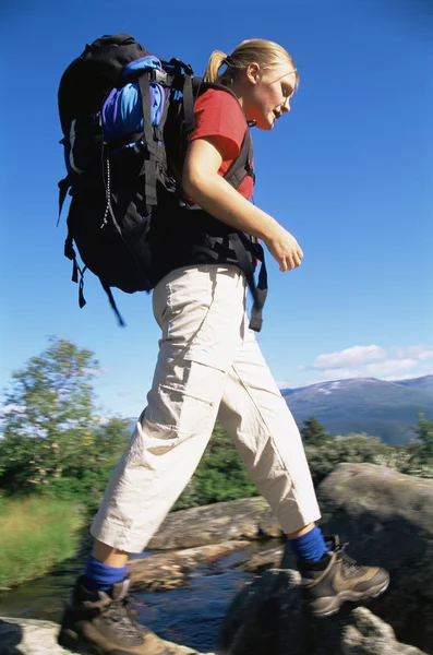 若い女性は川を渡ってハイキング — ストック写真