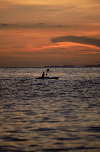 Deniz kanosu günbatımı sırasında insan silüeti — Stok fotoğraf