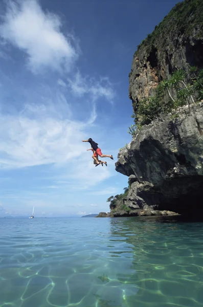 Par hoppa från klippor i havet — Stockfoto