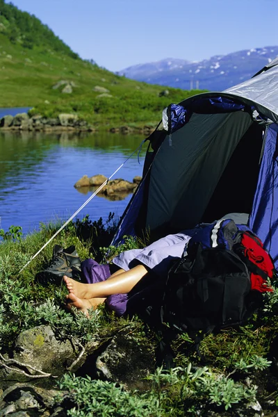 Mladá žena spí ve stanu u jezera, — Stock fotografie