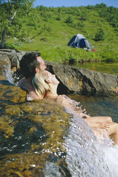 Casal sentado em água corrente na borda dos lagos — Fotografia de Stock