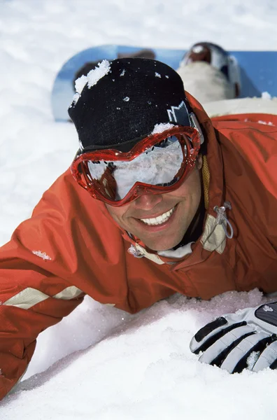 躺在雪地里的年轻滑雪板 — 图库照片
