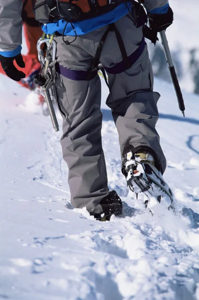 Young man mountain climbing on snowy peak — Stock Photo, Image