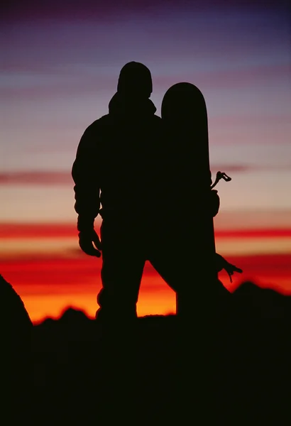 stock image Silhouette of snowboarder against sunset