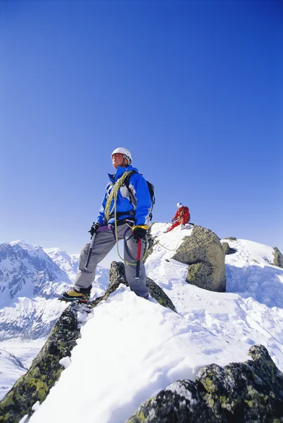 Wspinaczka górska młodych mężczyzn na snowy szczyt — Zdjęcie stockowe