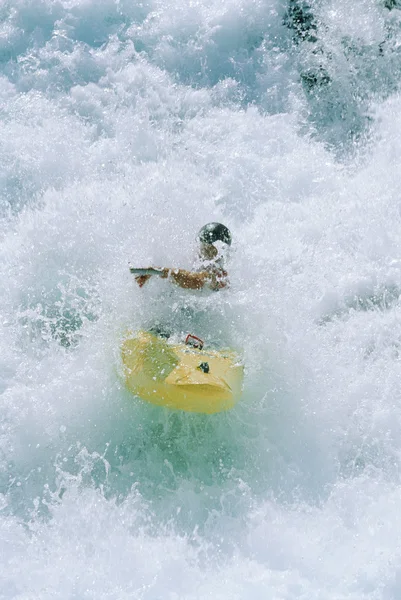 Молодой человек плавает на байдарках по порогам — стоковое фото