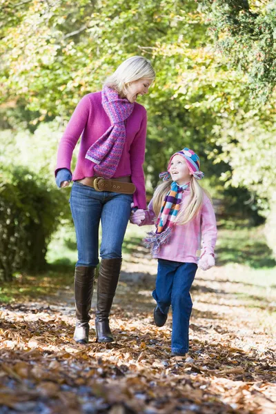 Matka a dcera, chůze po podzimní cesty — Stock fotografie