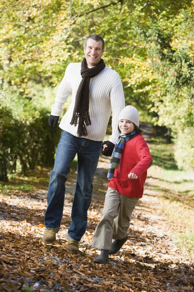 Apa és fia, őszi kerti ösvény mentén futó — Stock Fotó