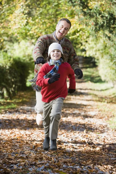 Grandfather and grandson running through woods — Stock Photo, Image