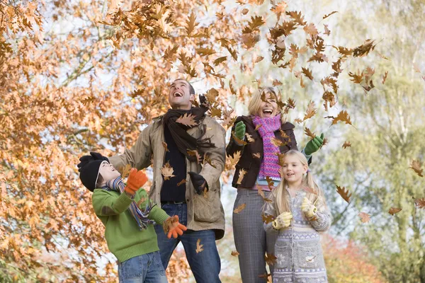 Famille jetant des feuilles dans l'air — Photo