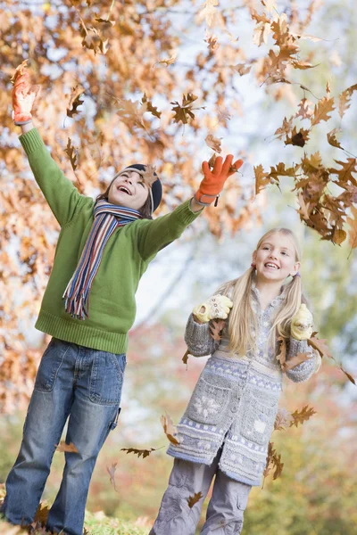 Deux enfants jetant des feuilles dans l'air — Photo