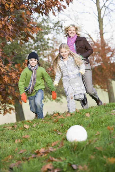 母亲和孩子们踢足球在秋天的花园 — 图库照片