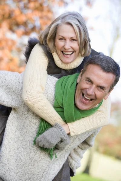 Senior Man Giving Woman Piggyback Ride Autumn Woods — Stock Photo, Image