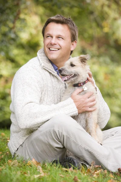 持株のペットの犬を外に座っている男 — ストック写真