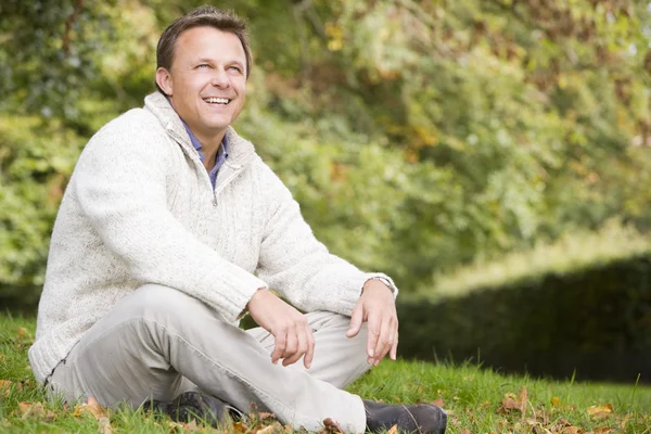 秋の風景の中の草で外に座って男 — ストック写真