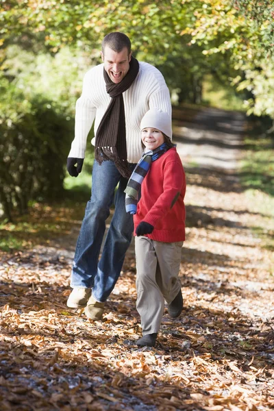 父亲和儿子在秋天沿林地路径运行 — 图库照片