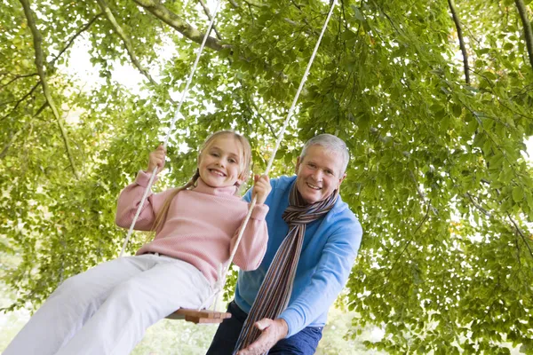 Grand-père poussant petite-fille sur swing — Photo