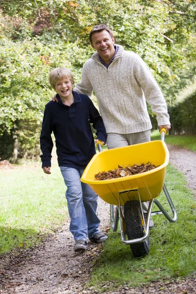Father and son pushing wheelbarrow — Stock Photo, Image