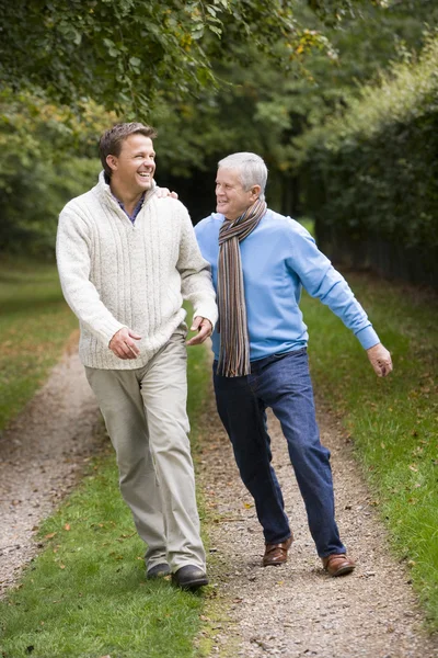 Stock image Father and grown up son walking along path