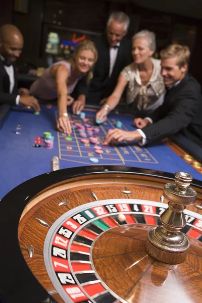 カジノでルーレットのテーブルでギャンブルをする友人のグループ — ストック写真