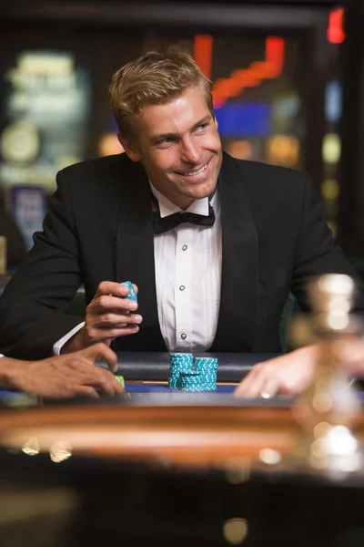 Hombre jugando en la mesa de ruleta en el casino — Foto de Stock