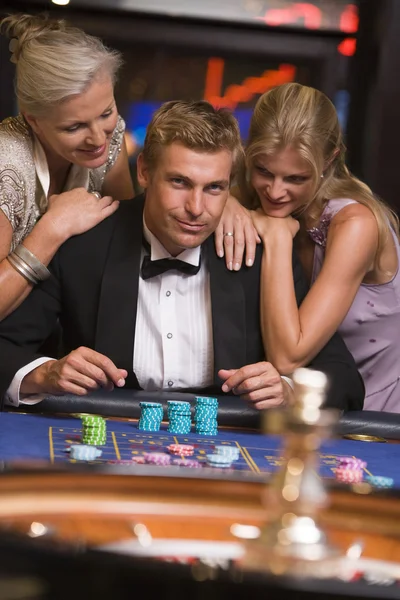 Człowiek Hazardu Otoczeniu Atrakcyjnych Kobiet Ruletce — Zdjęcie stockowe